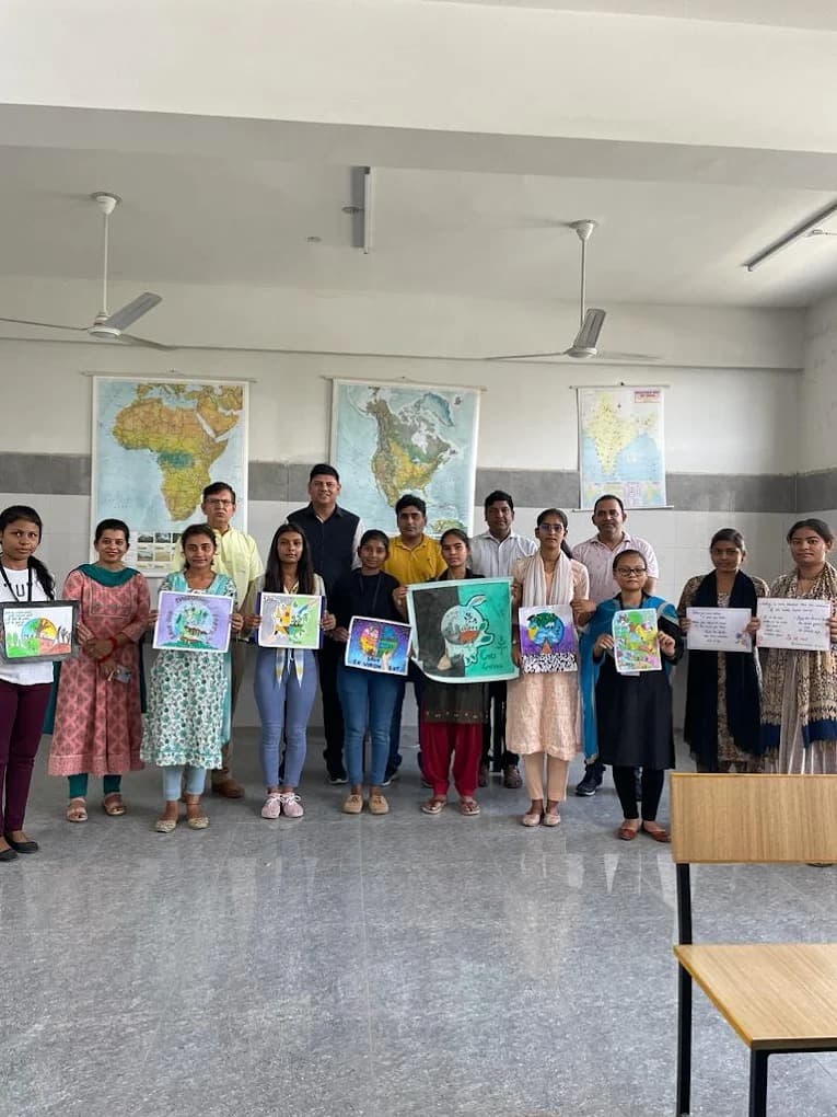 Students holding up hand-made posters in a classroom, alongside programme facilitators.