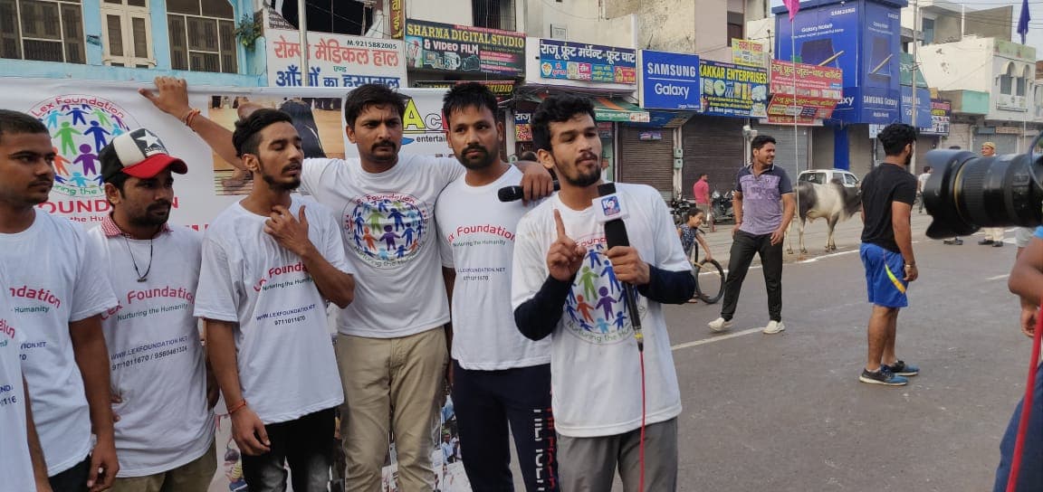 Lex Foundation volunteers in branded t-shirts speaking to a reporter on a city street.